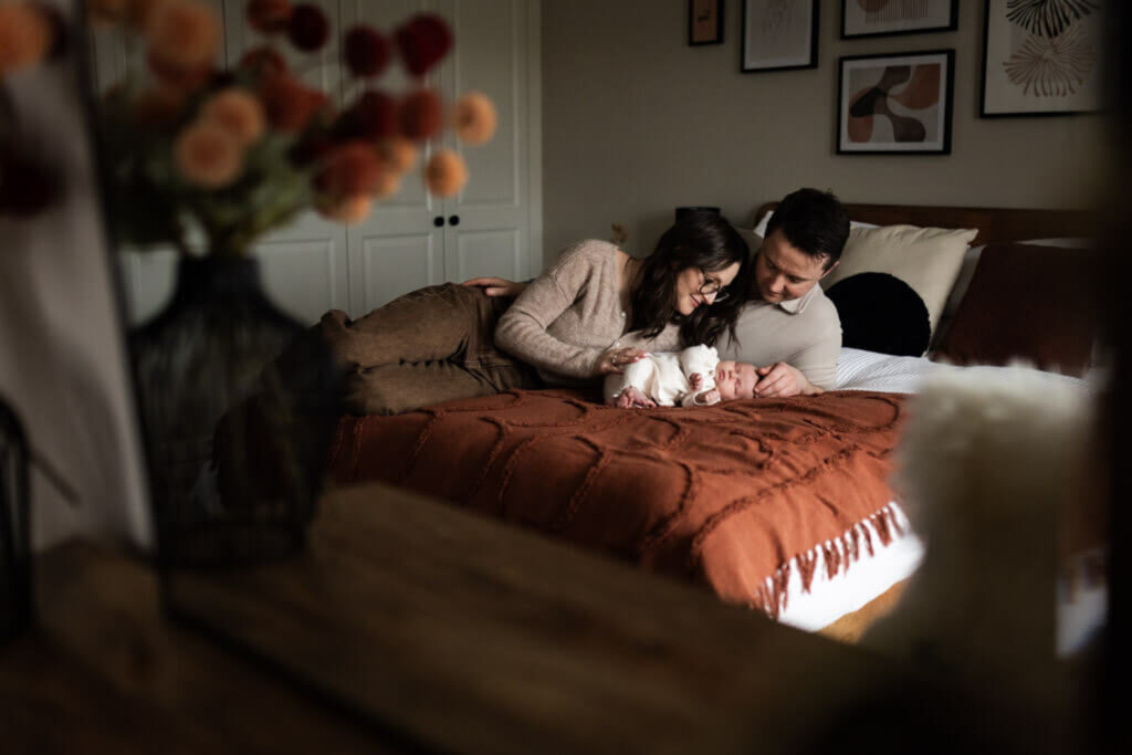 parents cuddling their newborn baby during an in-home newborn photography session in Glasgow