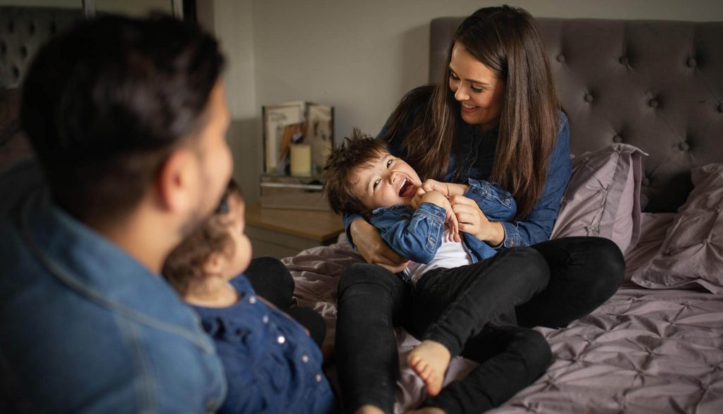 family cuddling together on the bed during an at-home photoshoot