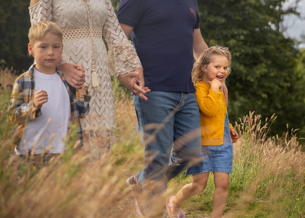 family of four with two pre school children walking in the park, summer family lifestyle photoshoot