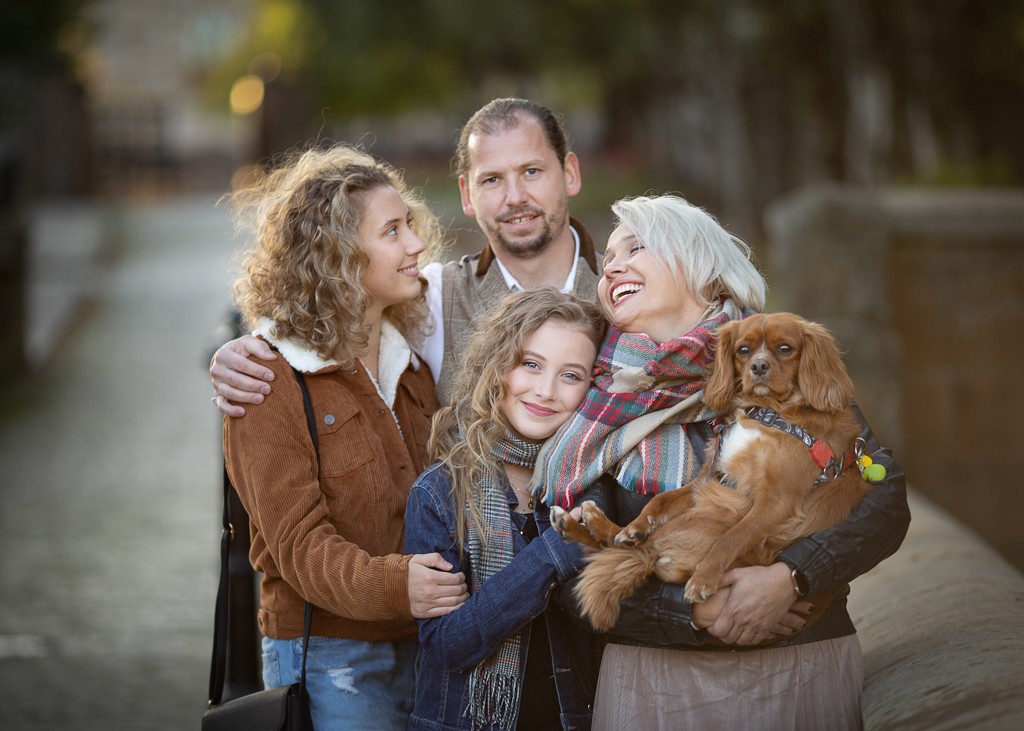 family portrait of four, mother, father, two teenager girl and brown cavalier next to St Mungo Cathedral, family autumn photoshoot