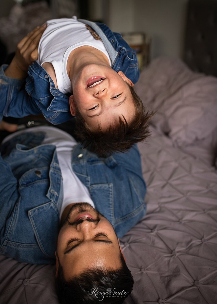 father and son tickling on the bed, family photoshoot at home