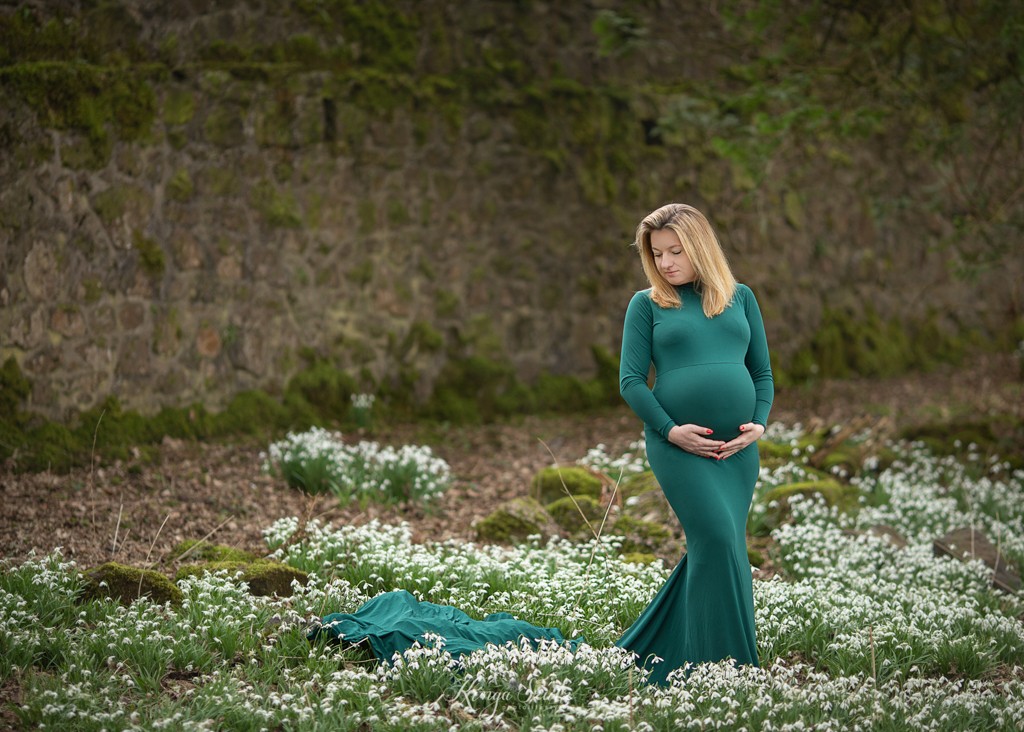 spring maternity photoshoot in pregnancy green dress among snowdropps at the Mugdock Country Park