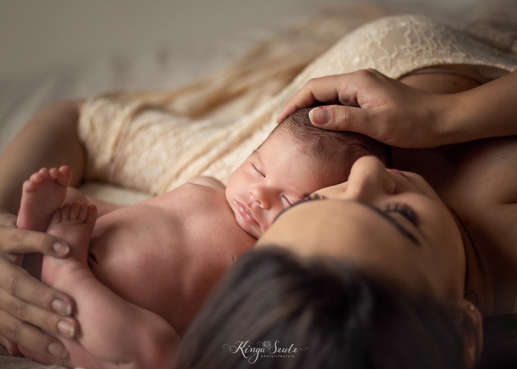 newborn baby girl with mother in boho lace dress cuddling on the bed, in home newborn photography