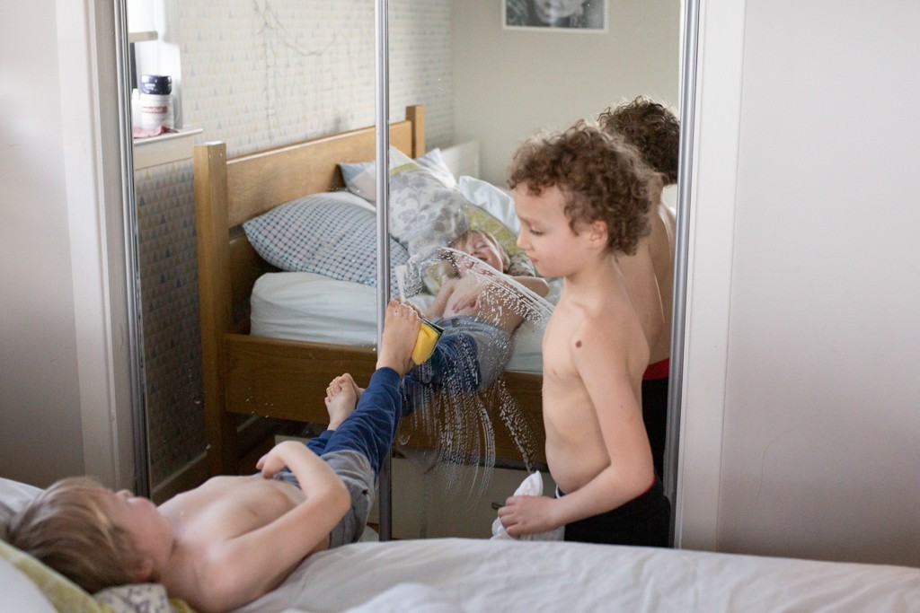 two boys cleaning window, in home family photoshoot
