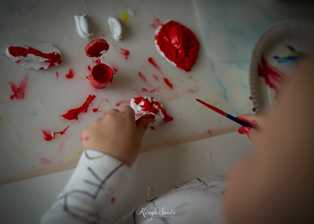toddle girl is painting stones, in home lifestyle photoshoot