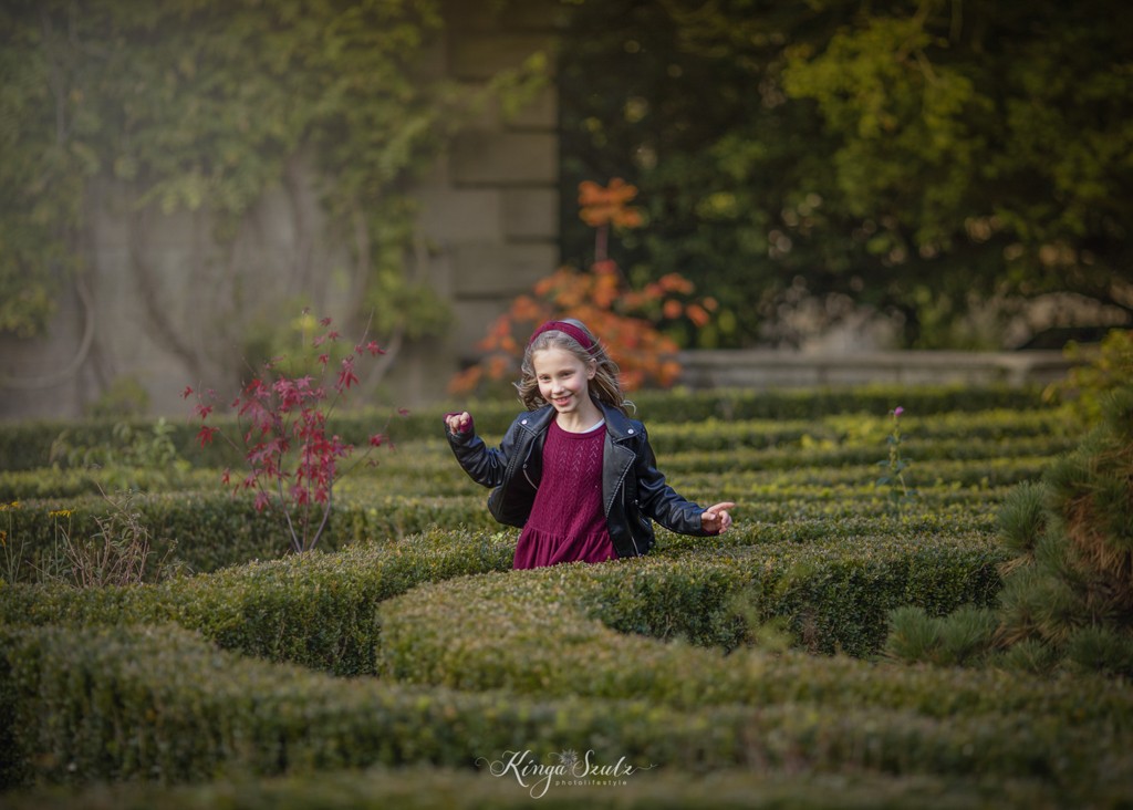 8 years old girl portrait in the dark fuchsia colour dress at the Pollok Country Park Gardens