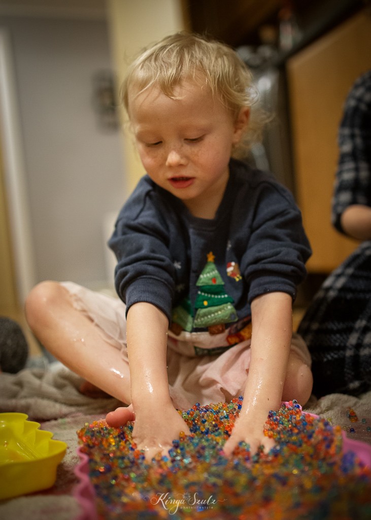 pre school girl playing rainbow colours slime, in home Family photoshoot