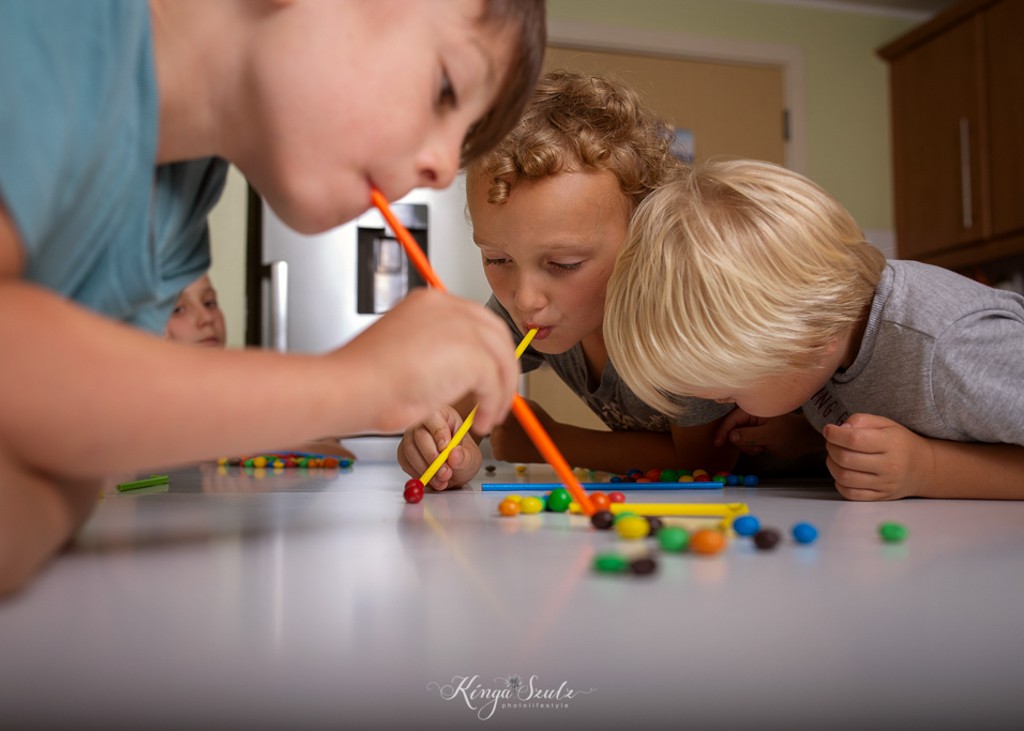 kids playing M&M Straw Game, family in home photoshoot
