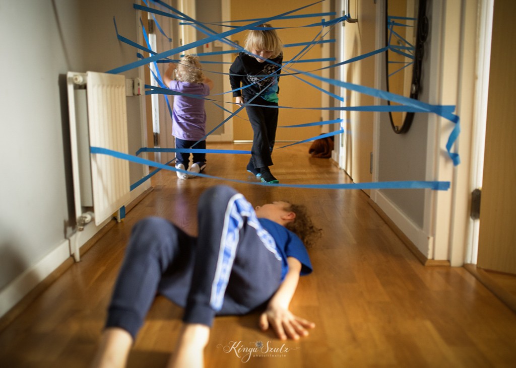 two boys and sister playing laser maze in the hallway, in home Family photoshoot