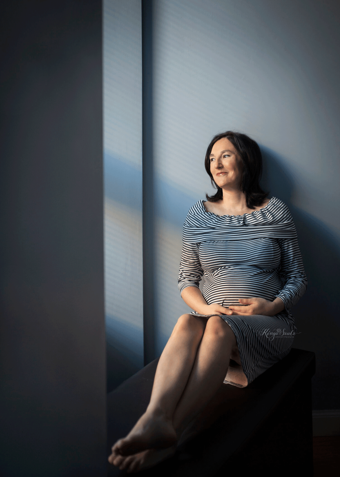pregnant woman in striped dress baby bump portrait in home photo session