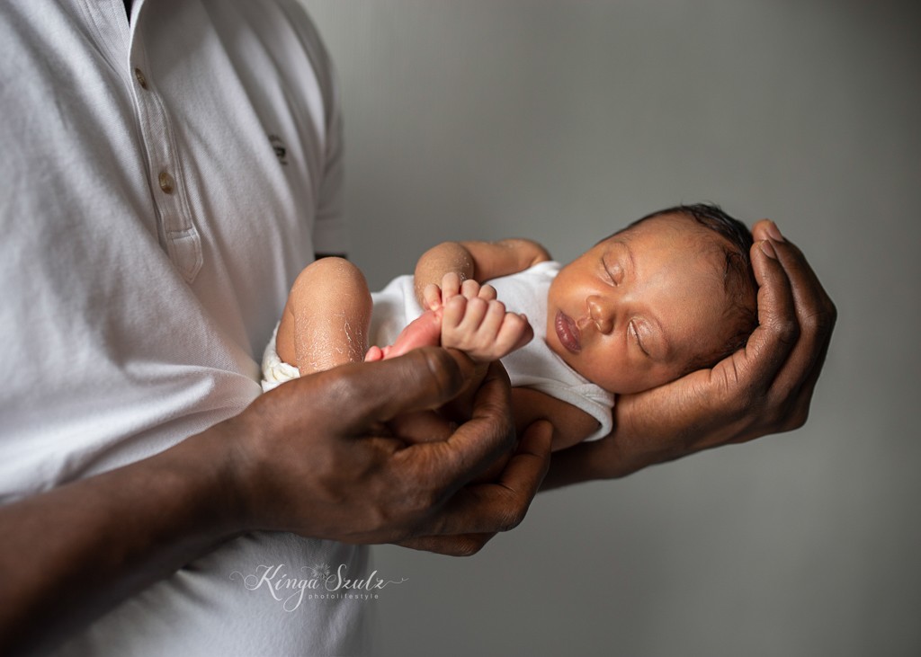 new baby girl laying on her dad's arms, lifestyle newborn photoshoot at home