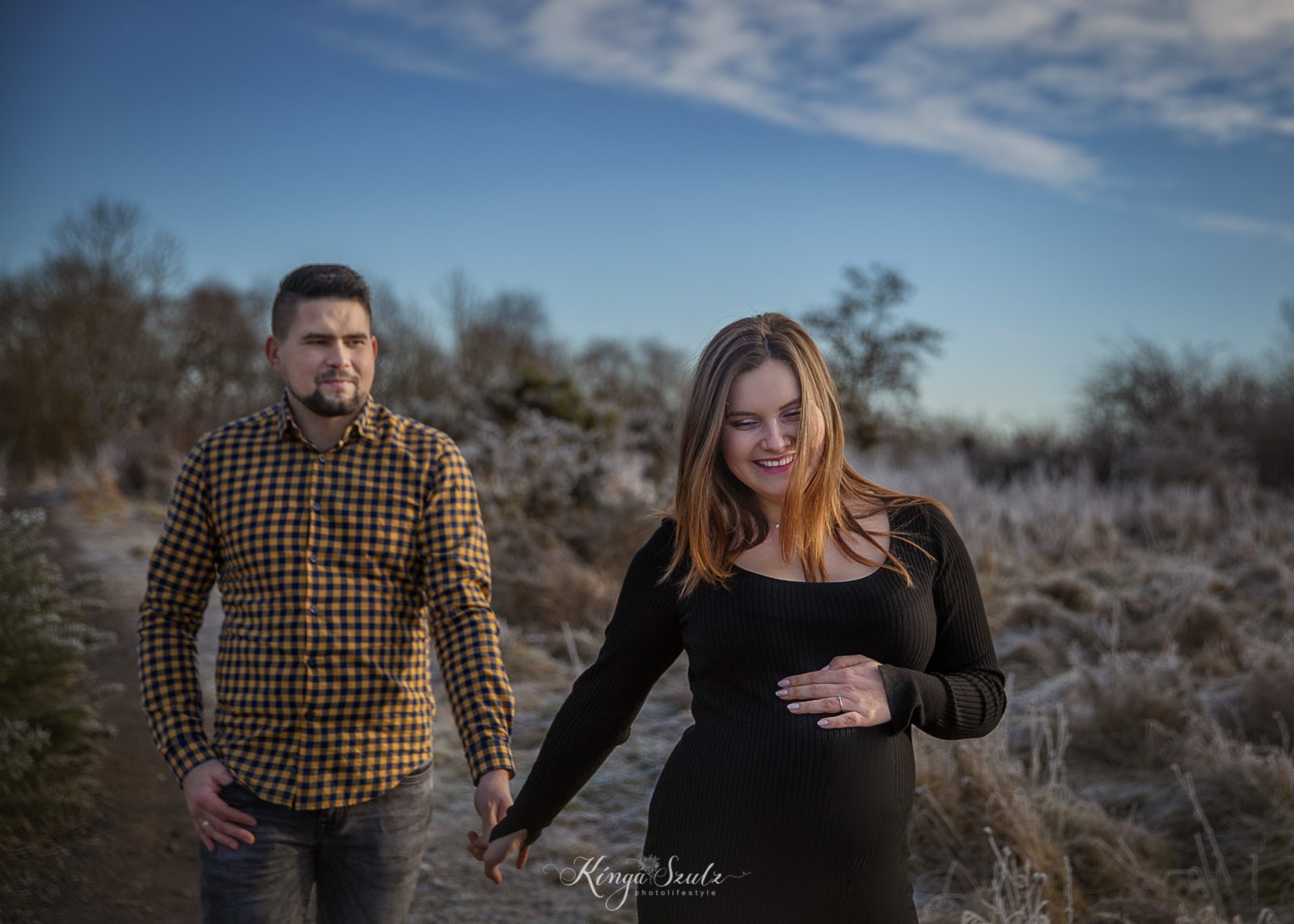pregnant couple, winter walk in the woodland and meadow