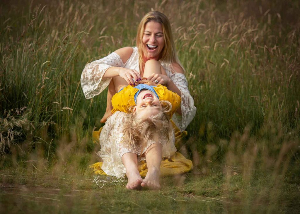 mother and daughter, summer family outdoor photoshoot at Mugdock Country Park Mother tickling her daughter during a summer outdoor family photoshoot in Glasgow