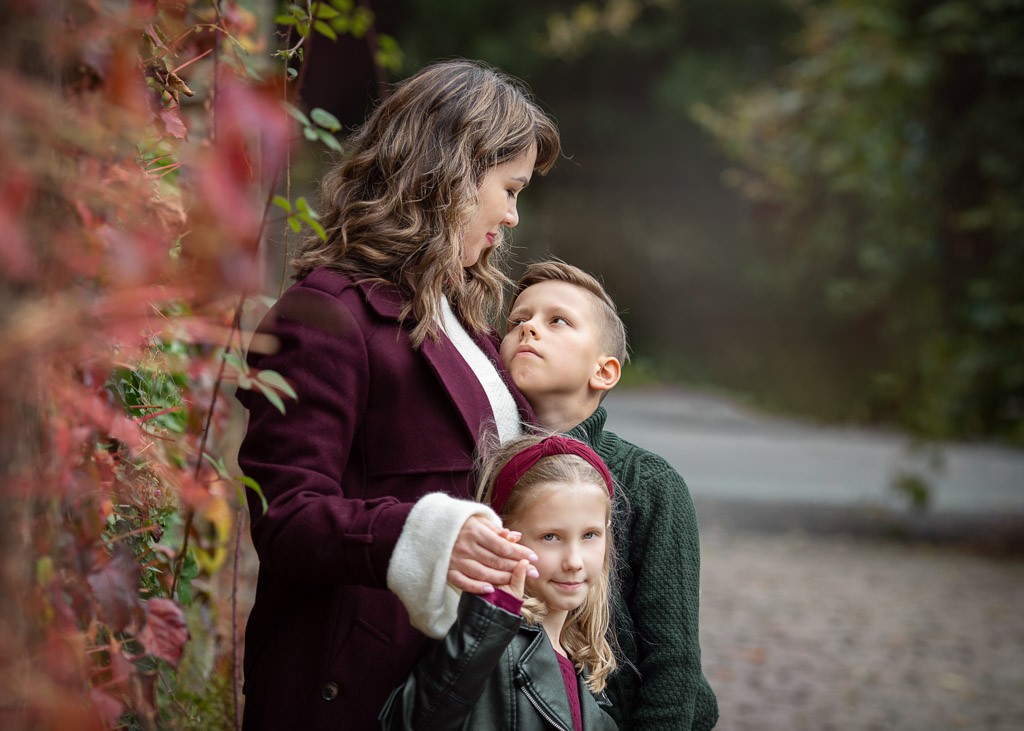 Mother looking lovingly at her son as he looks back at her during a family photoshoot in Glasgow at Pollok Country Park