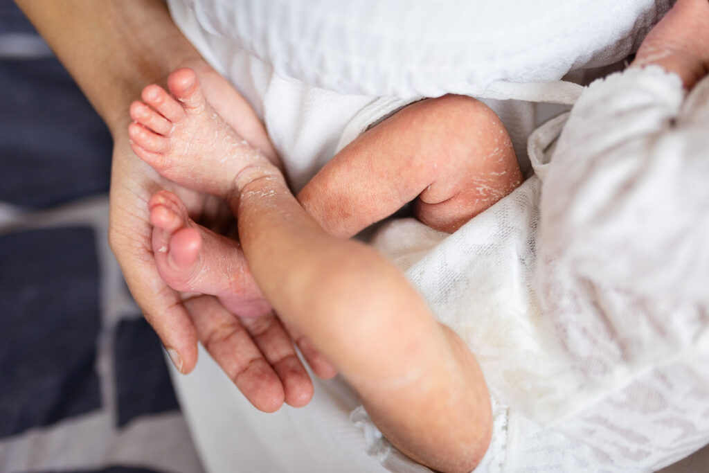 Close-up of newborn baby's feet resting in a parent's hands during an at-home newborn photoshoot in Glasgow