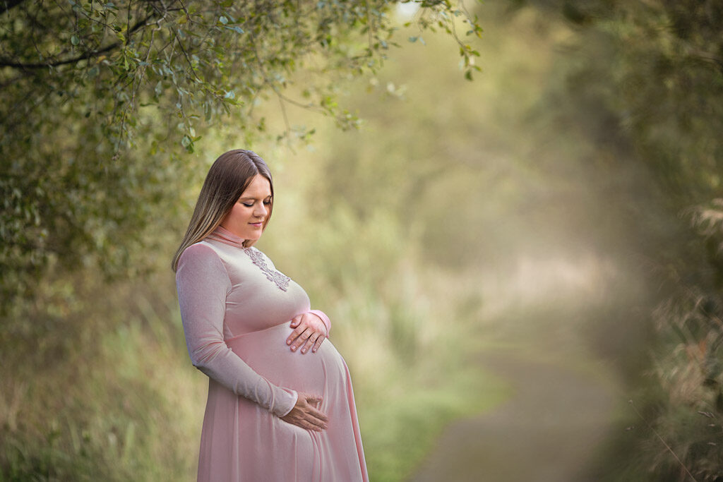 Glasgow Maternity Photography with pregnant women in pink long dress at the woodland paths