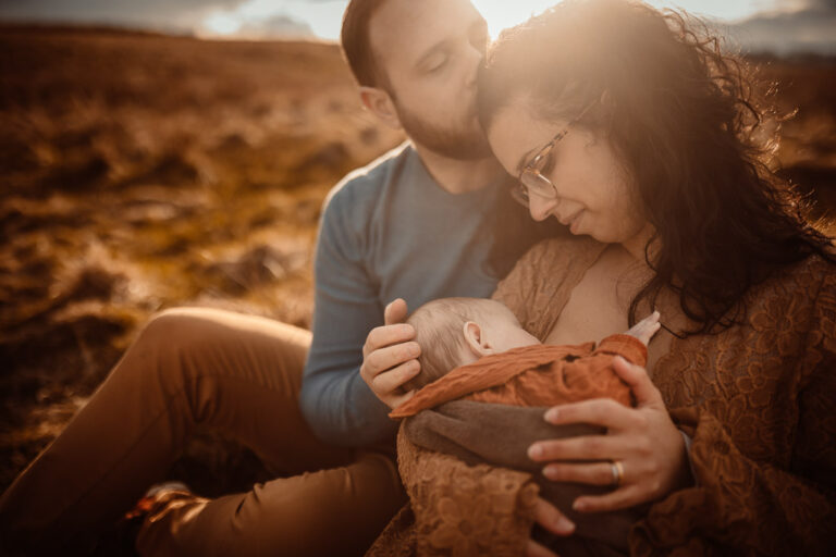 Parents with their baby and older daughter during an outdoor family newborn photoshoot in Glasgow