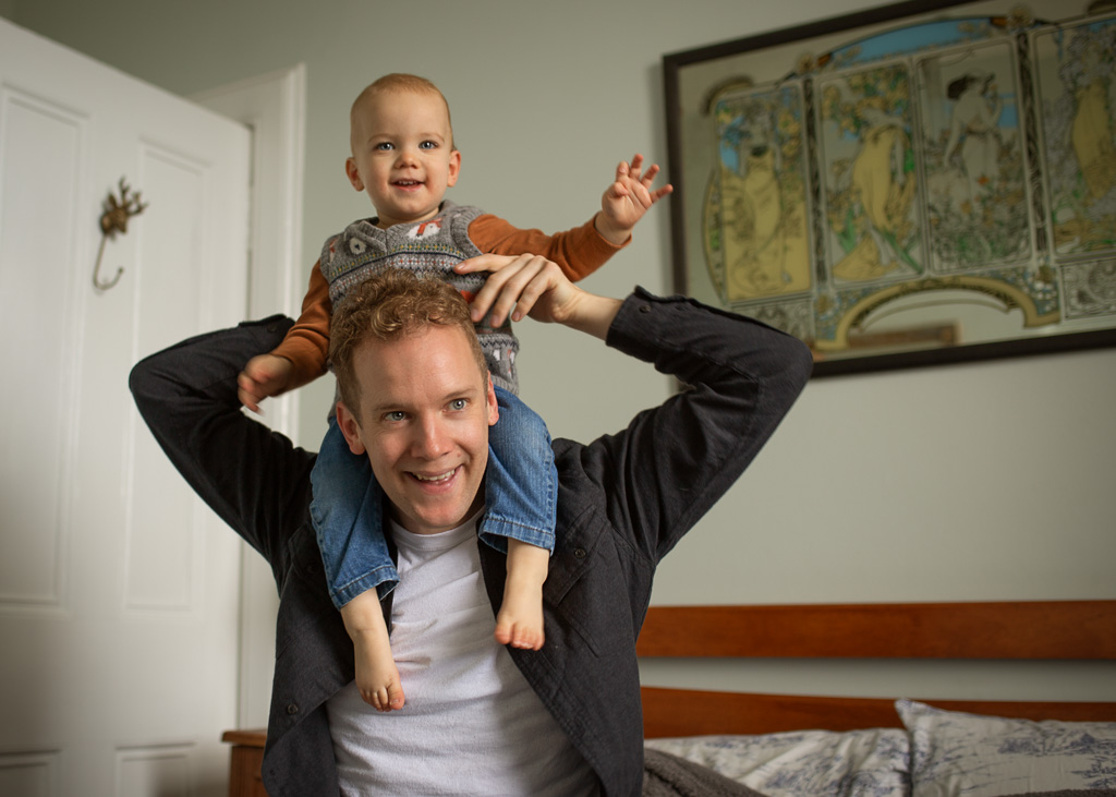 dad with son play on the bed during an at-home family photoshoot