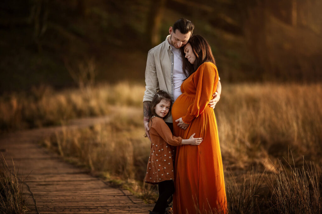 Mother and daughter wearing matching orange dresses during a warm-toned autumn outdoor photoshoot in Glasgow