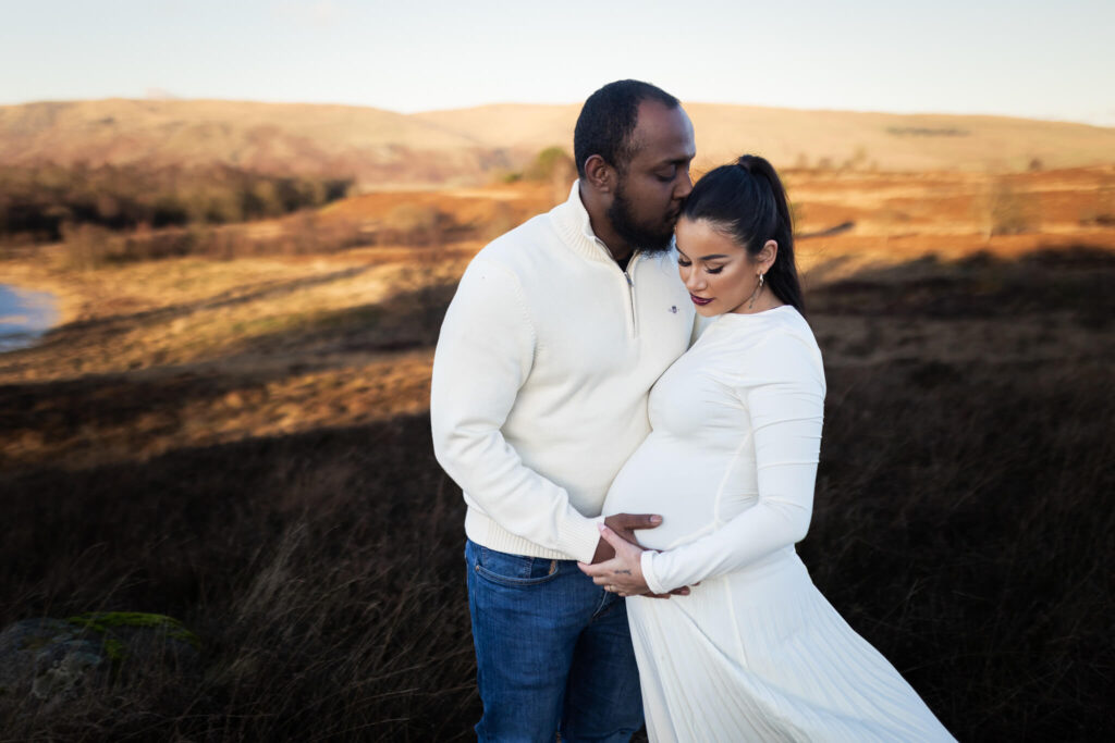 Expectant couple enjoying scenic views near Campsite Hills during a maternity photoshoot in the Scottish countryside, Sstrathblane
