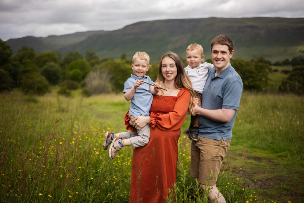 Family posing for a photo and looking at the camera during an outdoor family photoshoot in Glasgow
