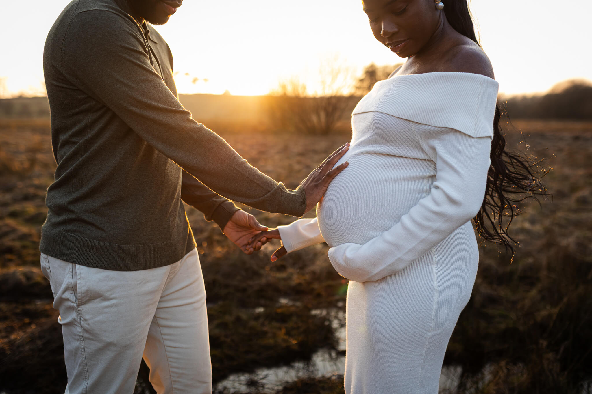 Expectant parents holding the baby bump during their maternity photoshoot