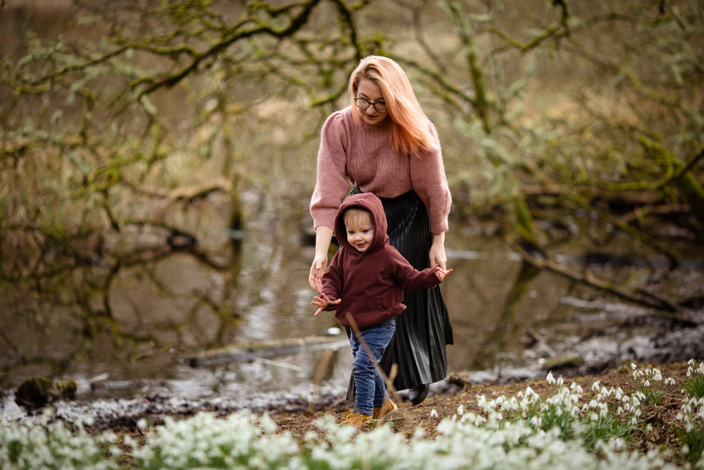 Mother and young son walking through snowdrops during an outdoor family photoshoot in Glasgow