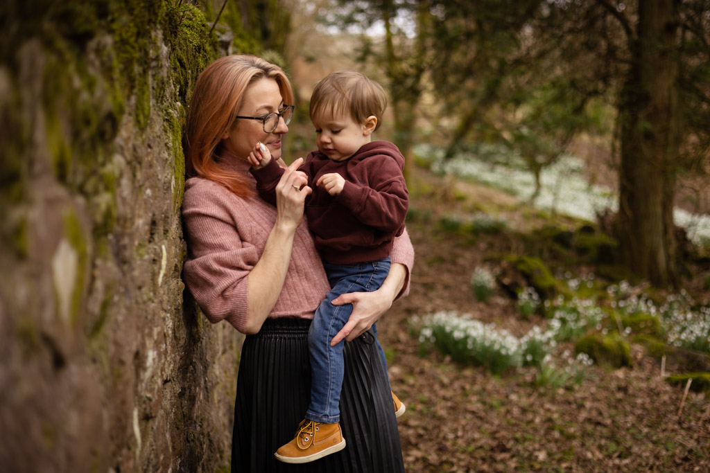 Mother holding her young son among snowdrops during a spring family photoshoot in Glasgow