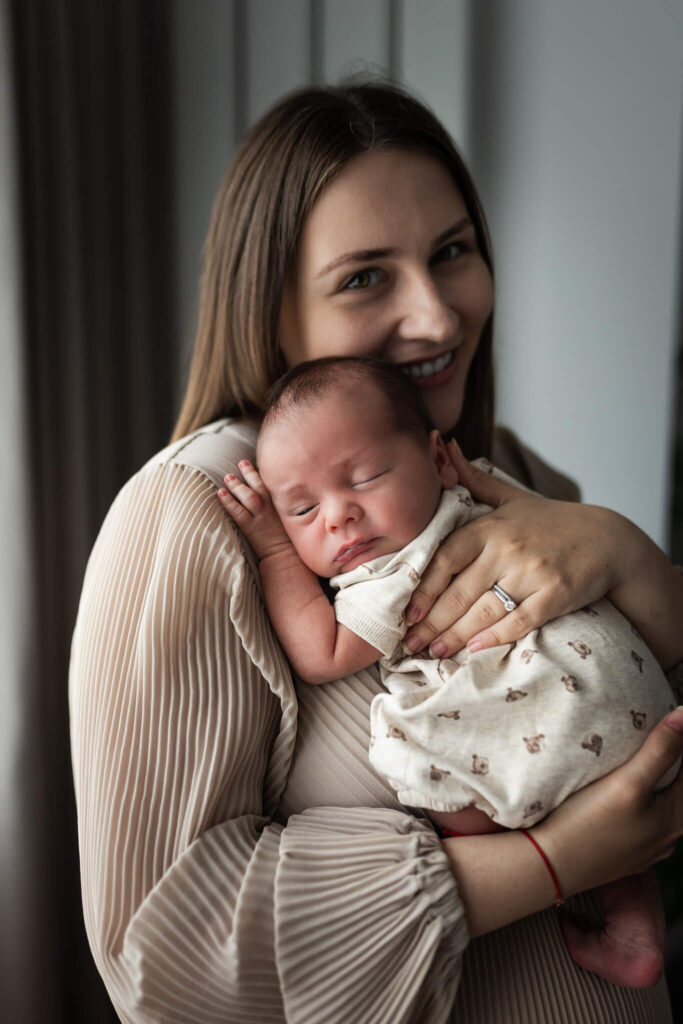 Mother holding her newborn baby during a natural photography session at home