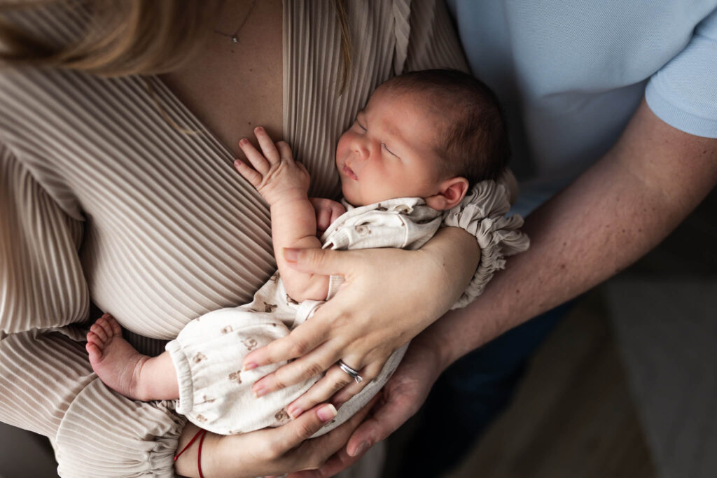 Sleeping newborn resting in their mother's arms during an at-home newborn photoshoot in Glasgow