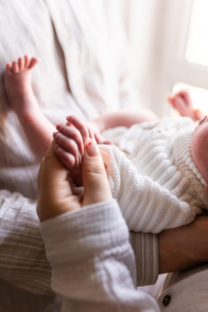 Newborn baby holding mother’s finger during a quiet moment at home